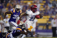 New Mexico running back Nathaniel Jones (25) carries against LSU linebacker Micah Baskerville (23) and linebacker Greg Penn III (30) in the second half of an NCAA college football game in Baton Rouge, La., Saturday, Sept. 24, 2022. LSU won 38-0. (AP Photo/Gerald Herbert)