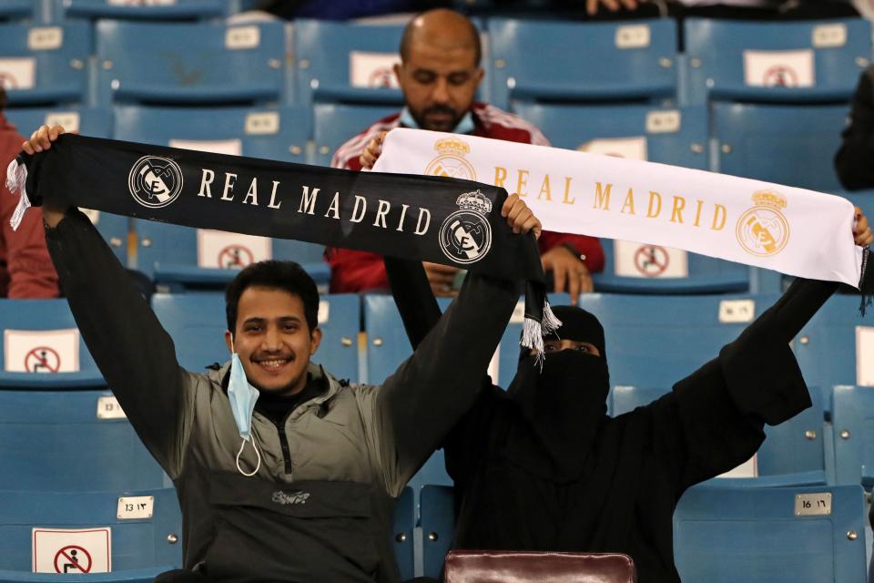 Un hombre y una mujer muestran su apoyo al Real Madrid durante su semifinal de la Supercopa. (Foto: AFP / Getty Images).