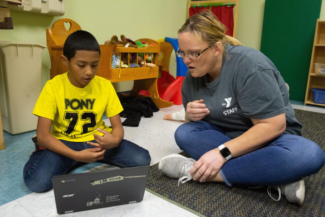 Nikki Rowland, staff member for the YMCA, helps a student with online work during the extended summer camp program at Covenant Baptist Church, 5440 S.W. 37th St. The organization will again host summer camps this year for youths pre-K through eighth grade.