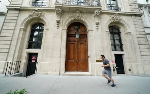 A man runs past the front door of the upper east side home of Jeffrey Epstein in New York. - Credit: Reuters