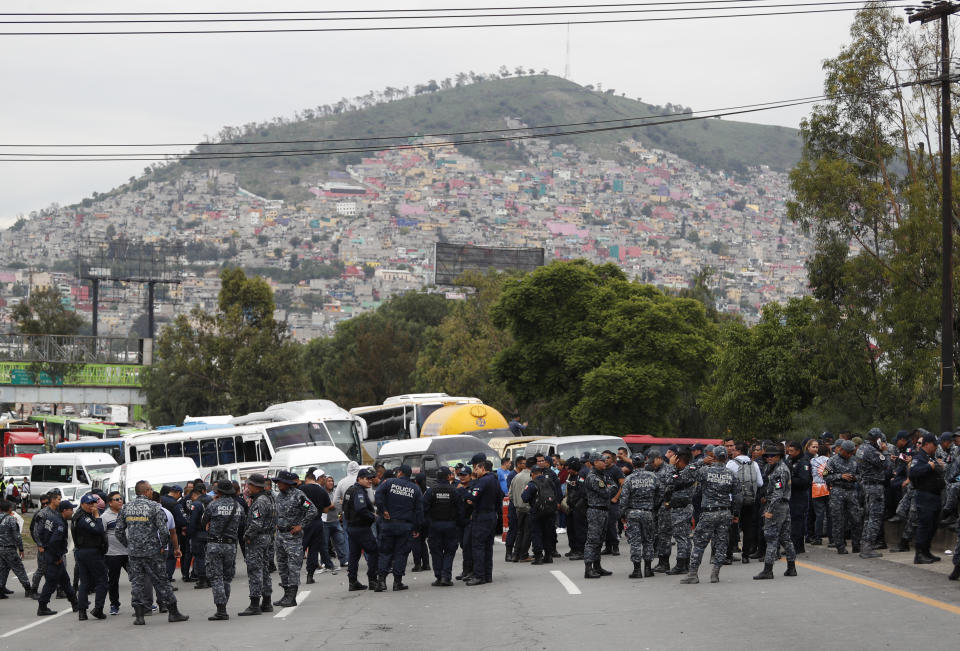 Uniformed federal police block the highway leading from Mexico City toward Pachuca, in Ecatepec, Wednesday, July 3, 2019. Hundreds of Mexican federal police are in open revolt Wednesday against plans to absorb them into the newly formed National Guard, saying their seniority, rank and benefits are not being recognized within the National Guard. (AP Photo/Rebecca Blackwell)