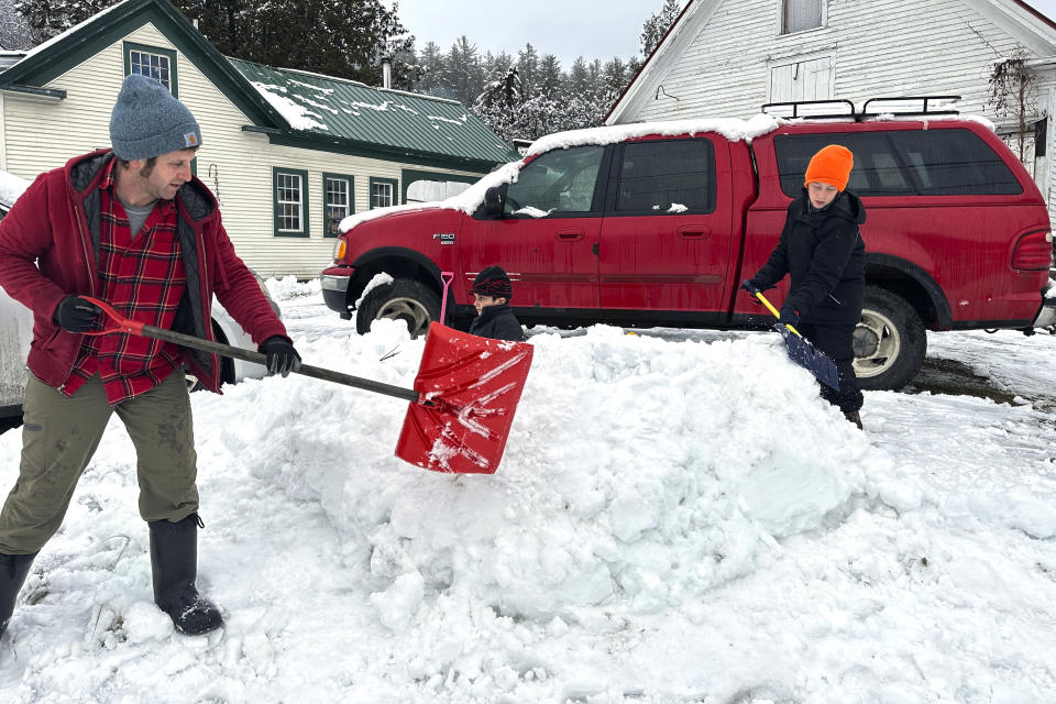 Dave Torres, left, Till Graves, center, and Henry Torres, right, build a snow cave, Monday Dec. 4, 2023, in Marshfield, Vt. A storm dropped a mix of rain and snow on parts of New England, with some locations recording more than a half-foot of snow. (AP Photo/Lisa Rathke)