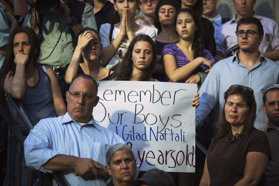 A woman holds a sign during a memorial service for three missing Israeli teenagers whose bodies were found in the occupied West Bank, near the United Nations headquarters in New York, June 30, 2014. Several hundred people waving Israeli flags and expressing grief and solidarity held a vigil in New York on Monday after the bodies of Eyal Yifrach, 19, Gilad Shaar, 16, and Naftali Fraenkel, 16, were found in a field near Hebron, a militant stronghold, not far from a road where they were believed to have been abducted while hitchhiking on June 12, security officials said. REUTERS/Lucas Jackson (UNITED STATES - Tags: POLITICS CIVIL UNREST)