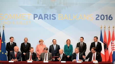 (Back row from L) Slovenian Prime Minister Miro Cerar, Italian Foreign Affairs minister Paolo Gentiloni, German Chancellor Angela Merkel, French President Francois Hollande, European Union High Representative for Foreign Affairs and Security Policy and Vice-President of the European Commission Federica Mogherini, Austria's Chancellor Christian Kern, Croatian Prime Minister Tihomir Oreskovic. (Front row from L) Macedonian Prime Minister Emil Dimitriev, Chairman of the Council of Ministers of Bosnia and Herzegovina Denis Zvizdic, Kosovo Prime minister Isa Mustafa, Montenegro's Prime Minister Milo Djukanovic, Prime Minister of Serbia Aleksandar Vucic sign an agreement on the creation of the Regional Youth Cooperation Office, during a western Balkans summit on July 4, 2016 at the Elysee Palace in Paris. REUTERS/Stephane De Sakutin/Pool
