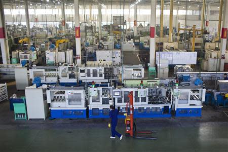 An employee works at a production line at a Wanxiang electric vehicle factory in Hangzhou, Zhejiang province, January 22, 2014. REUTERS/Aly Song