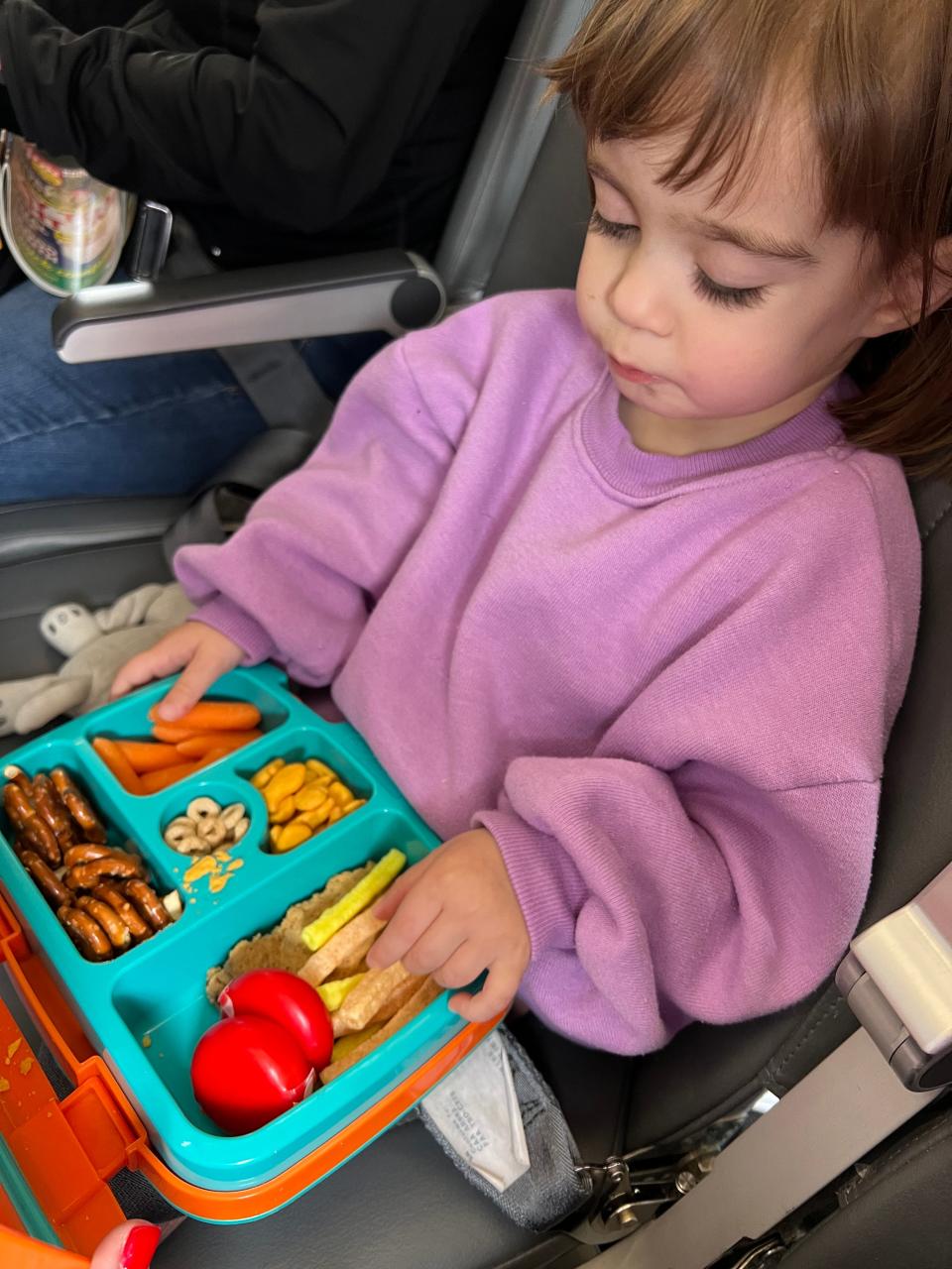 Conz Preti's daughter eating a snack on plane