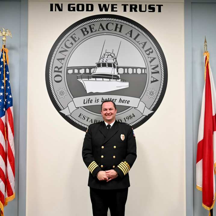 Jeff Smith stands in front of the city of Orange Beach logo in a city council meeting on April 16.