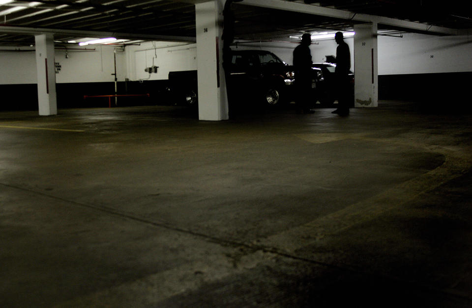 ROSSLYN, UNITED STATES:  A reporter (R) confers with a man in the shadows next to column 32 on D floor of the garage at 1401 Wilson Blvd 01 July 2005 in Rosslyn, VA, where Washington Post reporter Bob Woodward had his clandestine meetings with former FBI official Mark Felt, otherwise know as 'Deep Throat', the secret source in the Watergate scandal that brought down the presidency of Richard M. Nixon in 1974. Following the sudden revelation of Deep Throat's identity in April 2005, Woodward, now an assistant managing editor at the Post, has authored a new book, 'The Secret Man', slated for release 06 July 2005.    AFP PHOTO/Jim WATSON  (Photo credit should read JIM WATSON/AFP/Getty Images)