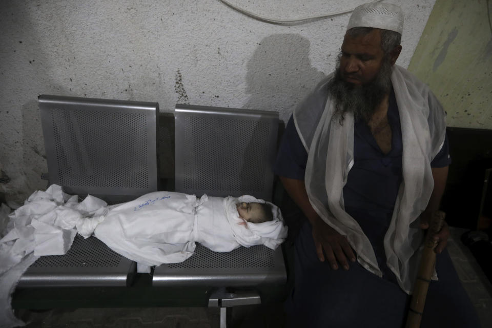 A Palestinian man sits while mourning his relative killed in the Israeli bombardment of the Gaza Strip at the morgue of the Kuwaiti Hospital in Rafah refugee camp, southern Gaza Strip, early Saturday, April 20, 2024. (AP Photo/Ismael Abu Dayyah)