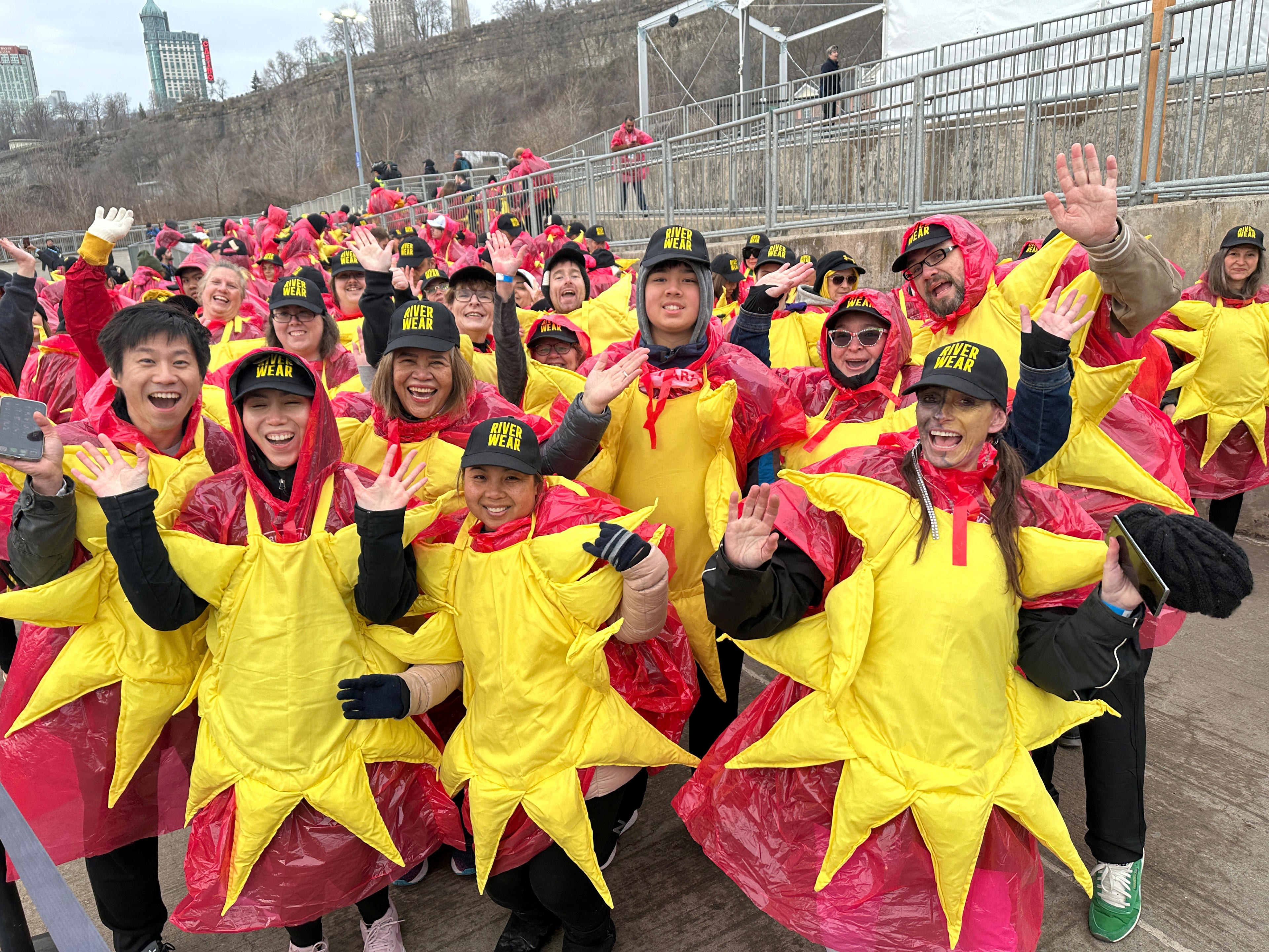 Some of the 309 people gathered to break the Guinness World Record for the largest group of people dressed as the sun pose while boarding a sightseeing boat, before the total solar eclipse in Niagara Falls, Ontario, Canada April 8, 2024.  (Kyaw Soe Oo/Reuters)