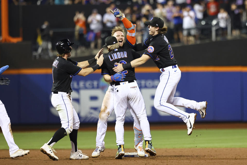 New York Mets' Pete Alonso, center right, celebrates with Francisco Lindor (12), Brett Baty, and Jeff McNeil after hitting a walkoff-single to defeat the Colorado Rockies during the bottom of the ninth inning of a baseball game on Friday, Aug. 26, 2022, in New York. (AP Photo/Jessie Alcheh)