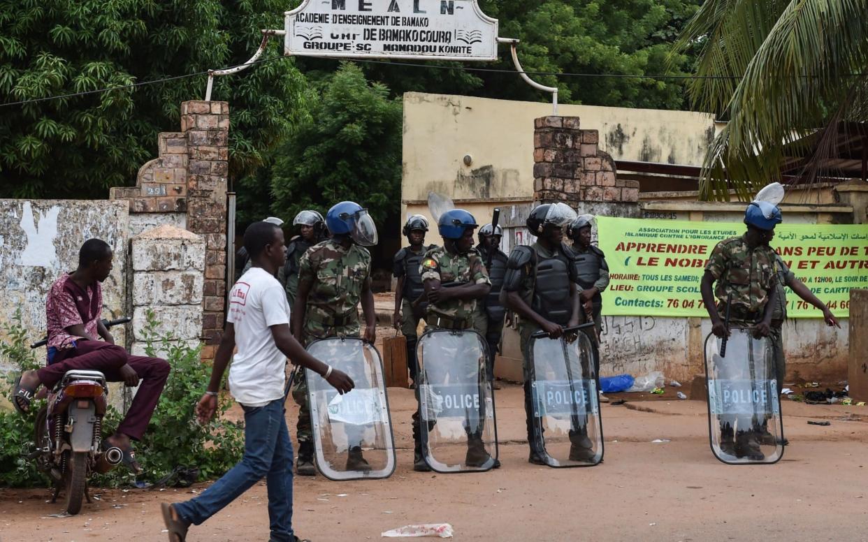 Malian police officers stand guard at the entrance of a polling station - AFP