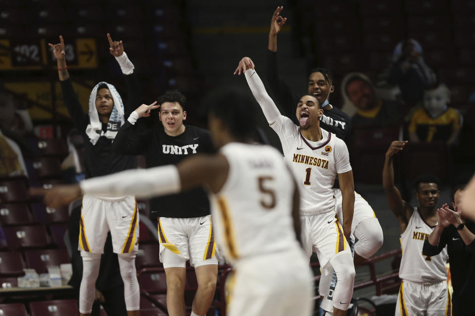 Minnesota players, including Minnesota's Tre' Williams (1), celebrate courtside after their team scored against Michigan State during the second half of an NCAA college basketball game, Monday, Dec. 28, 2020, in Minneapolis. Minnesota won 81-56. (AP Photo/Stacy Bengs)