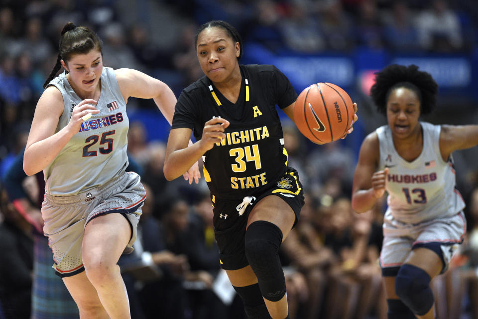 Wichita State's Shyia Smith (34) takes off with a steal while pursued by Connecticut's Kyla Irwin (25) during the first half of an NCAA college basketball game Thursday, Jan. 2, 2020, in Uncasville, Conn. (AP Photo/Jessica Hill)