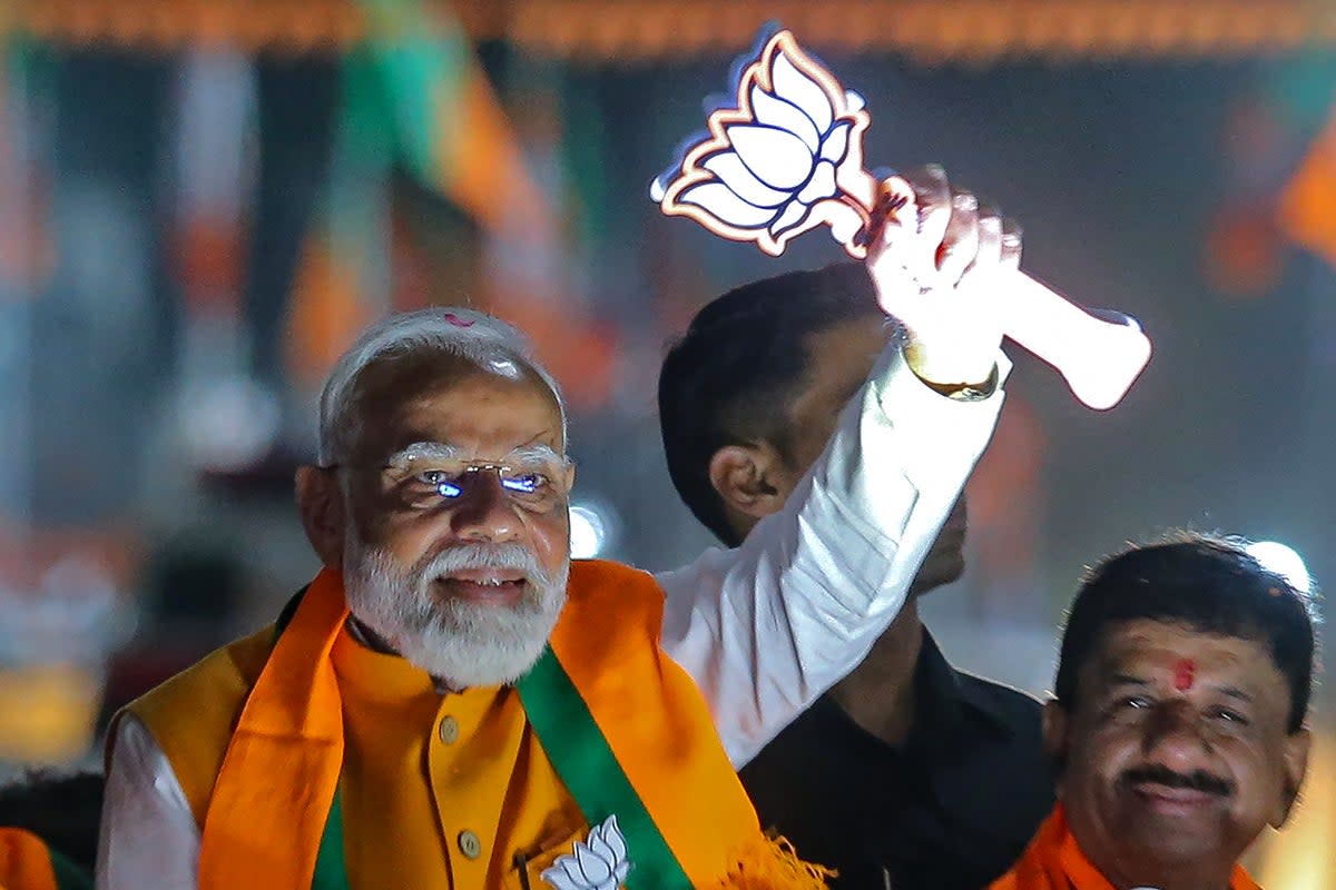 Narendra Modi greets supporters during a campaign roadshow in Bhopal on 24 April 2024 (AFP via Getty)