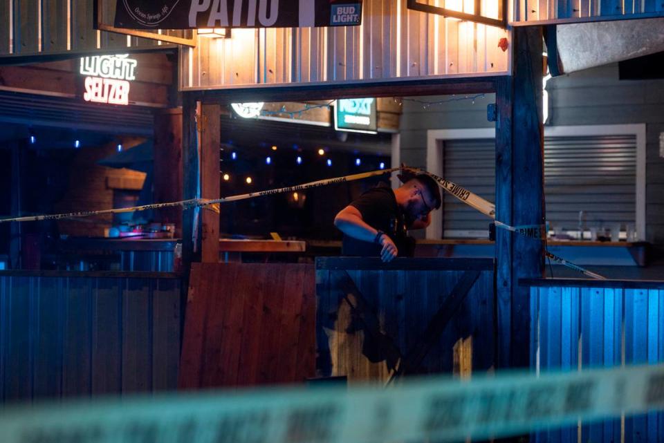 A law enforcement officer enters crime scene tape surrounding The Scratch Kitchen restaurant in Ocean Springs after a shooting left 1 dead and several injured on Friday, May 5, 2023.