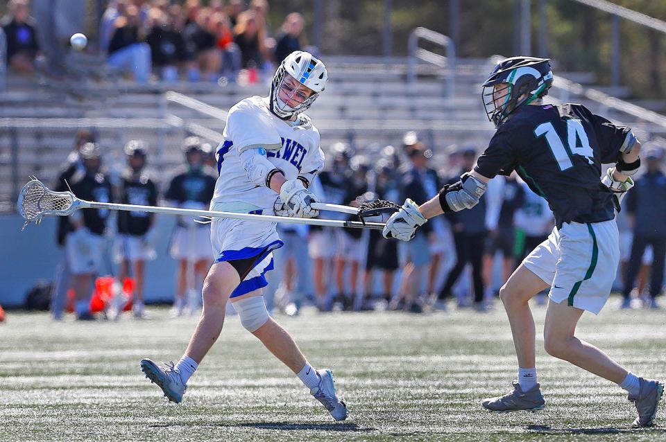 Norwell midfielder Dylan McGuirk shoots and scores past Rams #14 Ryland McGlame. Marshfield lacrosse hosted Norwell in the "Chowda Cup" semifinals on Thursday, April 20, 2023.