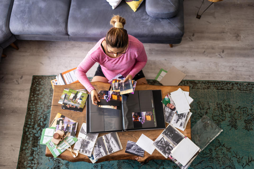 A woman in a pink shirt organizes photos for her album