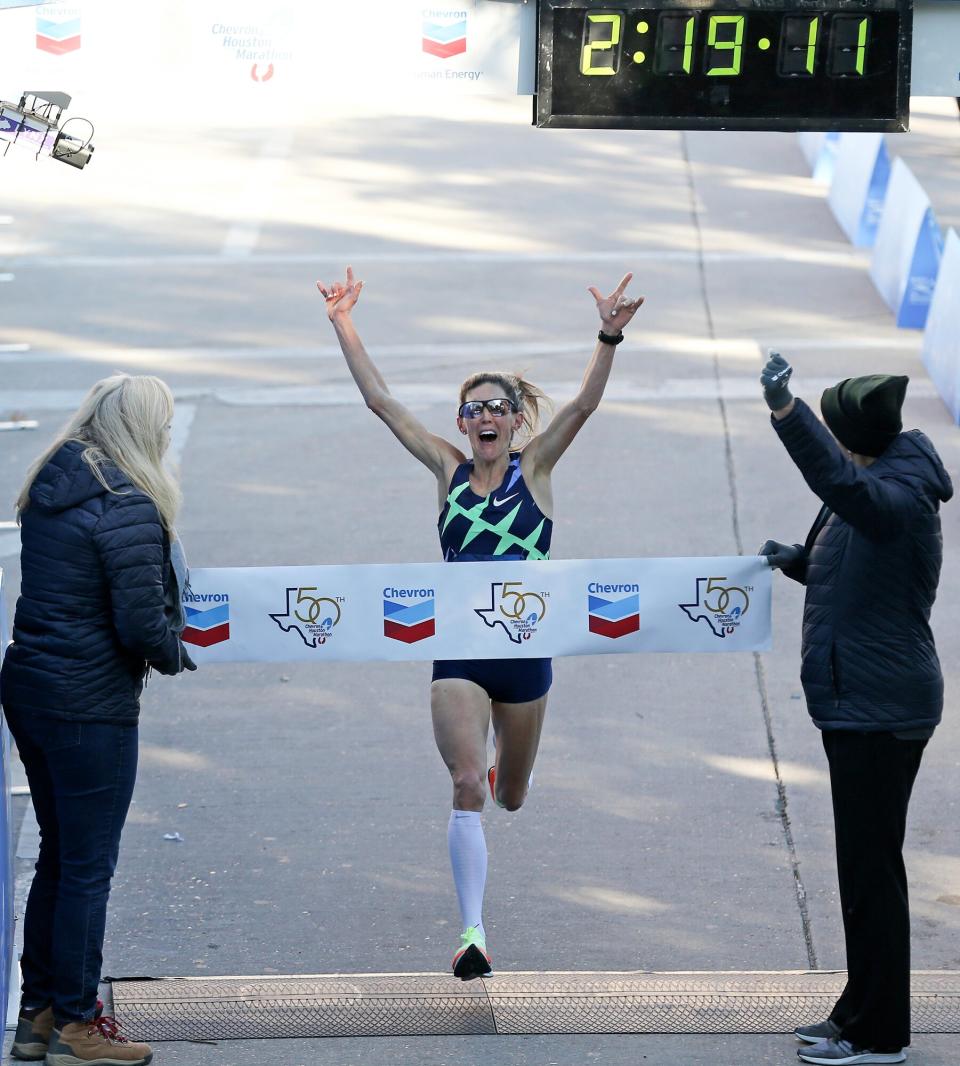 Keira D'Amato celebrates as she crosses the line for the Chevron Houston Marathon, breaking the Houston and the American Women's record clocking in at 2:19:12 on Sunday, Jan. 16, 2022.