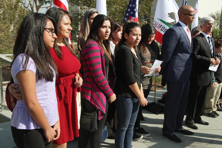 Attorneys Theodore Boutrous, far right, and Marcellus McRae, second from right , take questions from the media, as they are joined by nine California public school students who are suing the state to abolish its laws on teacher tenure, seniority and other protections, during a news conference outside the Los Angeles Superior court Monday, Jan. 27, 2014 downtown Los Angeles. Their case Vergara v. California is the latest battle in a growing nationwide challenge to union-backed protections for teachers. (AP Photo/Nick Ut)