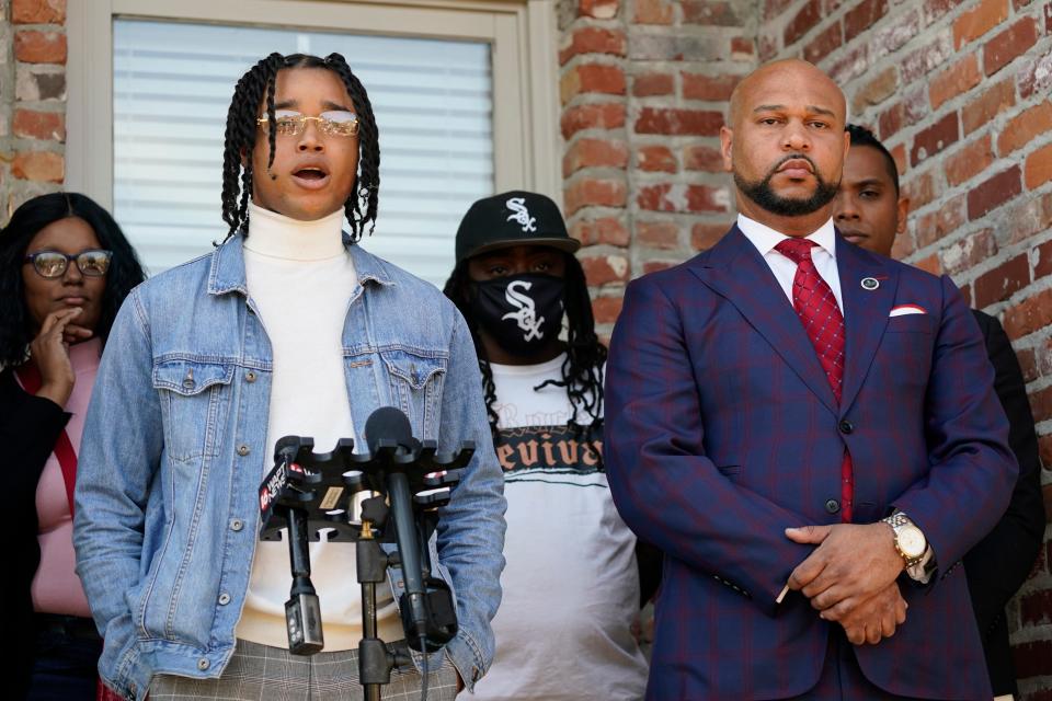 FedEx driver D'Monterrio Gibson, left, stands with family members and one of his attorneys, Carlos Moore, right.