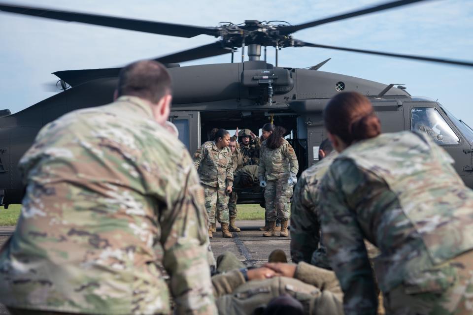 Airmen escort a person onto a helicopter at Maxwell Air Force Base during training in March.