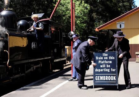 Staff at the Puffing Billy railway station of Lakeside put out a sign for the next arriving train as locomotive 14A is watered on the platform near Melbourne, REUTERS/Jason Reed