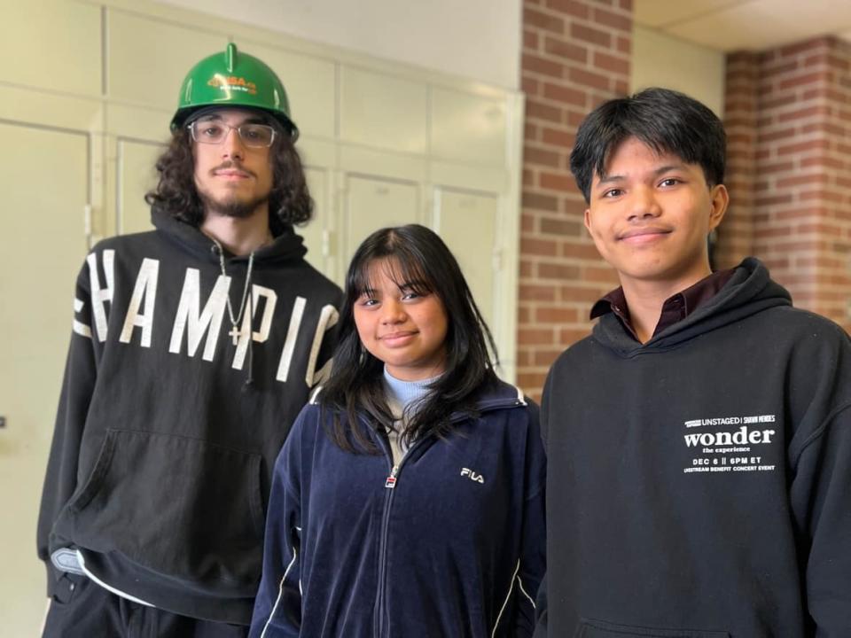 From left, high school students Nathan Godet, Khate Agne and Ace Tabisaura are taking a Toronto District School Board co-op course called Step to Construction, which lets them work with different skilled tradespeople on a construction site across one semester.  (Nazima Walji/CBC - image credit)