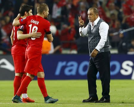 Turkey's coach Fatih Terim celebrates with his players Caner Erkin and Sener Ozbayrakli as his team defeated Iceland during their Euro 2016 Group A qualification soccer match in Konya, Turkey, October 13, 2015. REUTERS/Umit Bektas