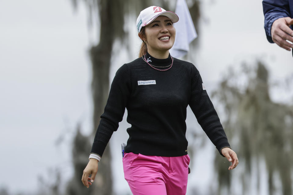 Ayaka Furue smiles after putting on the 18th green during the first round of the Hilton Grand Vacations Tournament of Champions LPGA golf tournament in Orlando, Fla., Thursday, Jan. 18, 2024. (AP Photo/Kevin Kolczynski)