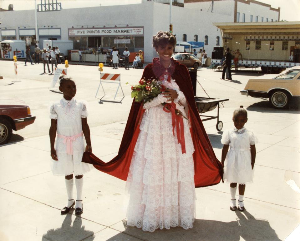 Miss Juneteenth in a crown and cape with two girls.