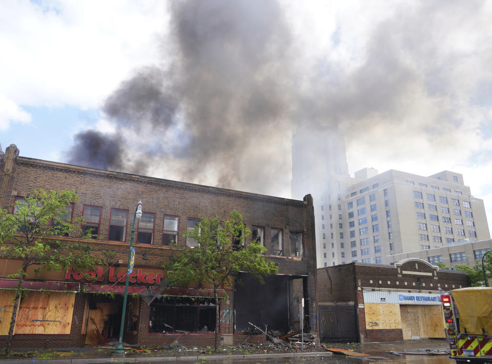 The Foot Locker Store and the apartments above it burn along Lake Street in the morning on Friday, May 29, 2020, in Minneapolis. Minneapolis residents awoke Friday to assess the damage after rioters ignited fires and looted stores all over the city, as peaceful protests turned increasingly violent in the aftermath the death of George Floyd during an arrest. (Brian Peterson/Star Tribune via AP)