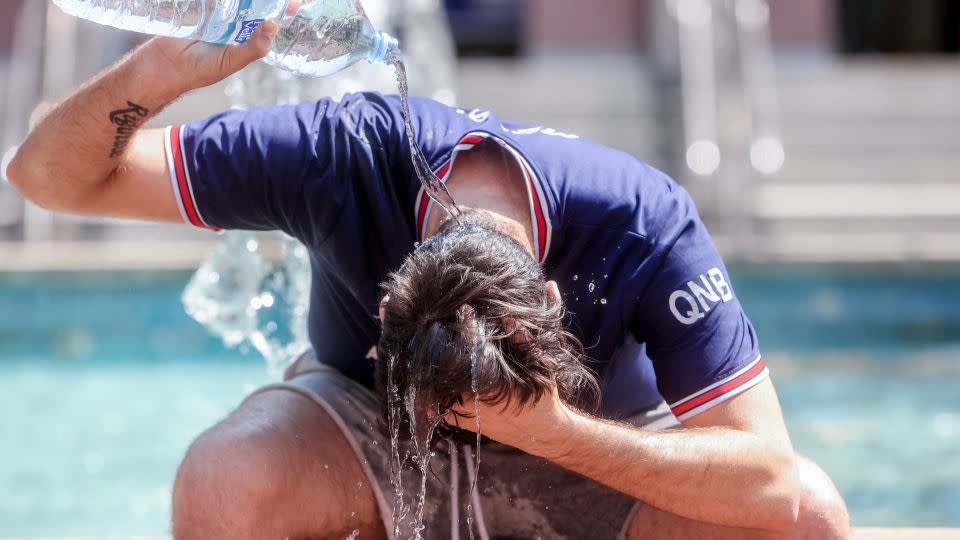 A young man throws a bottle of water over himself to combat the heat on 12 July, 2022 in Madrid, Spain.  - Ricardo Rubio/Europa Press/Getty Images