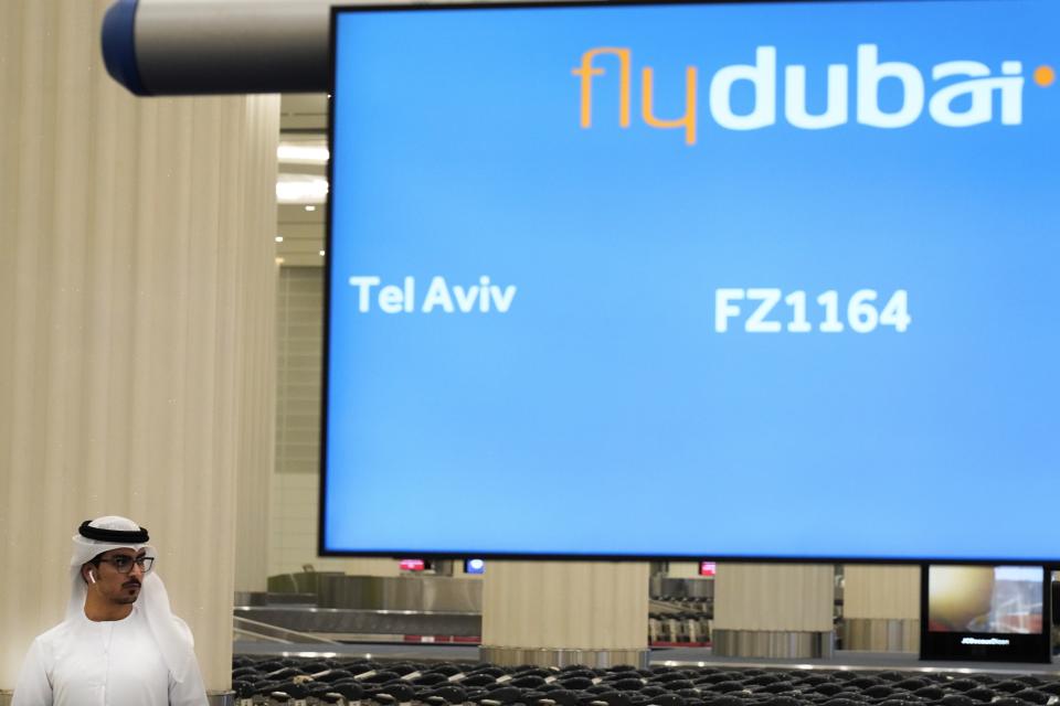 An Emirati journalist awaits a flyDubai flight from Tel Aviv, Israel, at Dubai International Airport's Terminal 3 in Dubai, United Arab Emirates, Thursday, Nov. 26, 2020. The low-cost carrier flyDubai began regular flights to Tel Aviv on Thursday, the latest sign of the normalization deal between the United Arab Emirates and Israel. (AP Photo/Jon Gambrell)