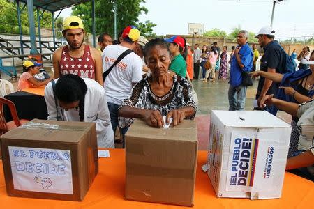 Una mujer deposita su voto durante el plebiscito no oficial contra el Gobierno del presidente de Venezuela, Nicolás Maduro, en Maracaibo, Venezuela, 16 de julio del 2017. REUTERS/Isaac Urrutia