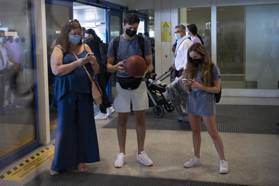 Fans of the NBA Champion Giannis Antetokounmpo, of the Milwaukee Bucks, who was named NBA Finals Most Valuable Player, wait at the Eleftherios Venizelos International Airport, in Athens, Greece, Sunday, Aug. 1, 2021. The NBA champion and finals MVP plans to stay in Greece for a few days, before returning to the U.S., where his girlfriend expects their second child later this month. (AP Photo/Michael Varaklas)