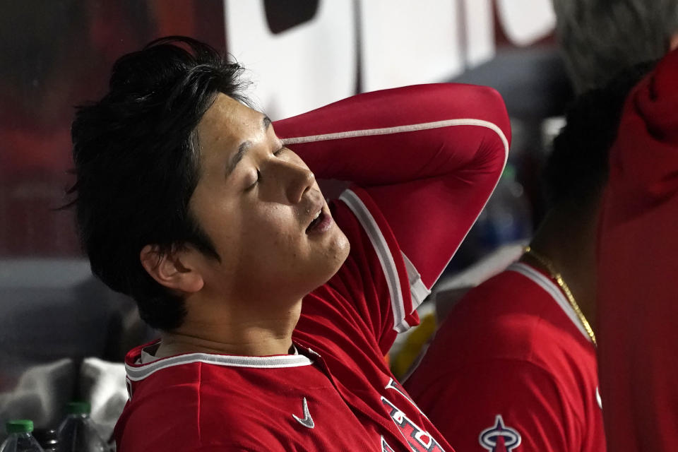 Los Angeles Angels' Shohei Ohtani sits in the dugout after being called out on strikes during the fourth inning of the team's baseball game against the Chicago White Sox on Tuesday, Sept. 14, 2021, in Chicago. (AP Photo/Charles Rex Arbogast)