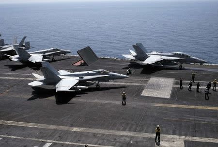 An F/A-18F Super Hornet of Strike Fighter Squadron (VFA-213) (R) and an F/A-18C Hornet of Strike Fighter Squadron (VFA-15) prepare for take off onboard the aircraft carrier USS George H.W. Bush in the Gulf August 13, 2014. REUTERS/Hamad I Mohammed