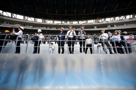Media members are seen at the construction site of the New National Stadium, the main stadium of Tokyo 2020 Olympics and Paralympics, during a media opportunity in Tokyo