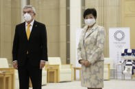 International Olympic Committee President Thomas Bach, left, and Tokyo Governor Yuriko Koike, right, pose for a photo, before their meeting in Tokyo, Monday, Nov. 16, 2020. IOC President Bach is beginning a visit to Tokyo to convince politicians and the Japanese public that the postponed Olympics will open in just over eight months.(AP Photo/Koji Sasahara)