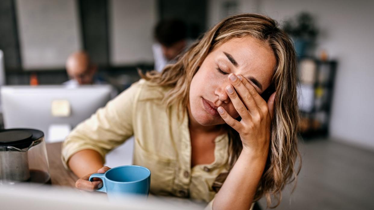 tired business woman rubbing eyes