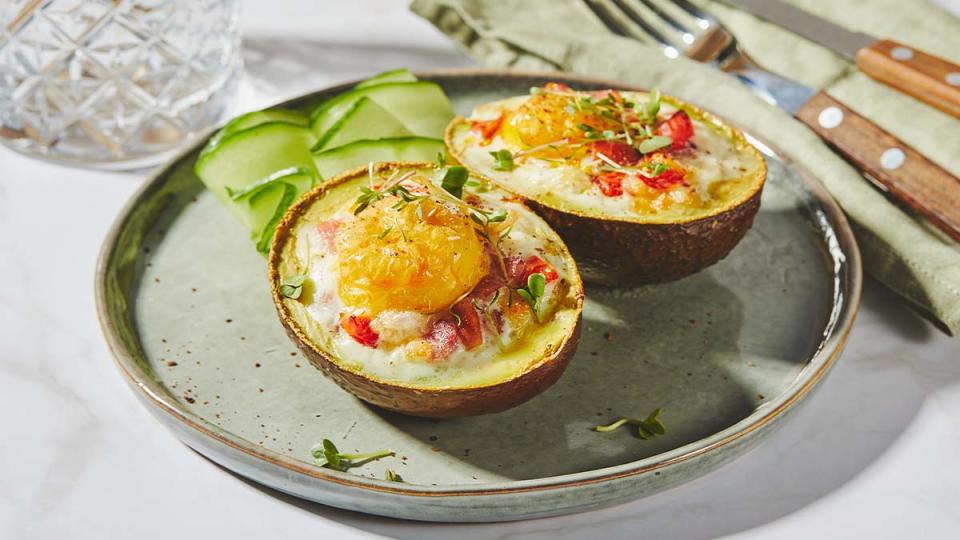 Eggs baked in avocado halves on a plate as part of a diet used by women who lost 150 lbs with no loose skin