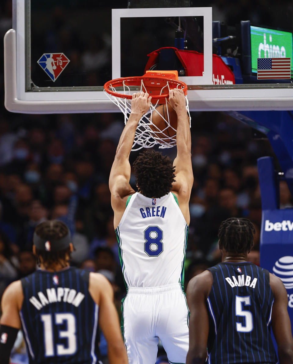 Dallas Mavericks guard Josh Green (8) dunks as Orlando Magic guard R.J. Hampton (13) and forward Mo Bamba (5) look on during the first half of an NBA basketball game, Saturday, Jan. 15, 2022, in Dallas. (AP Photo/Brandon Wade)