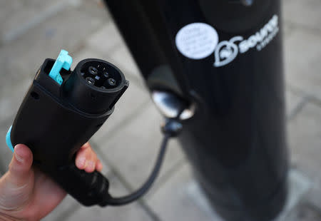 A woman uses an electric car charging point in London, Britain September 1, 2017. REUTERS/Hannah McKay