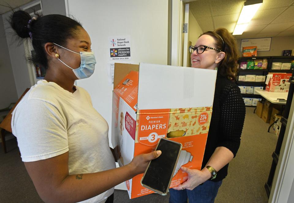 Kris Dotson picks up diapers from Debbie Hollis at Basic Necessities.