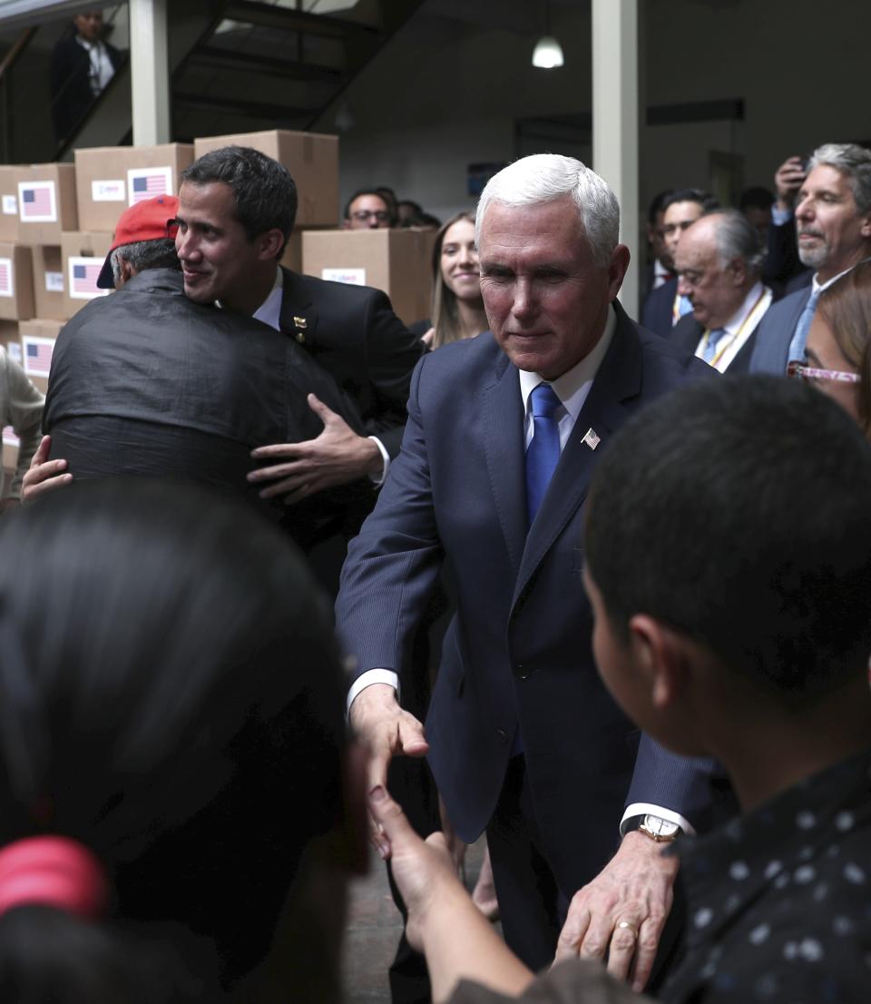 Vice President Mike Pence, right, and Venezuela's self-proclaimed interim president Juan Guaido, left back, meet Venezuelan citizens after attending a meeting of the Lima Group concerning Venezuela at the Foreign Ministry in Bogota, Colombia, Monday, Feb. 25, 2019. Pence arrived in the Colombian capital for an emergency summit of regional leaders to discuss Venezuela's crisis and immediately met with Guaido. In a speech to the group, Pence urged regional partners to freeze oil assets controlled by Maduro, transfer the proceeds to Guaido and restrict visas for Maduro's inner circle. (AP Photo/Martin Mejia)