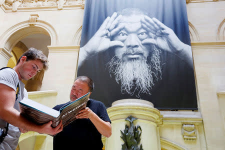 Chinese artist and free-speech advocate Ai Weiwei signs his book ahead of an exhibition titled "Ai Weiwei: By the way, it's always the others" at the Musee Cantonal des Beaux Arts in Lausanne, Switzerland September 20 2017. REUTERS/Pierre Albouy