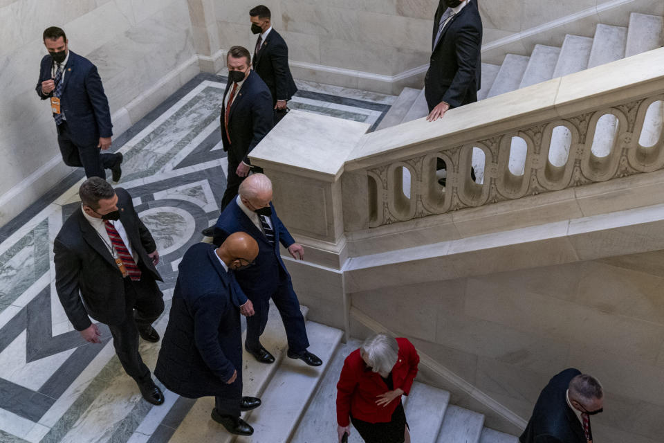 President Joe Biden, at center, leaves a meeting with the Senate Democratic Caucus to discuss voting rights and election integrity on Capitol Hill in Washington, Thursday, Jan. 13, 2022. (AP Photo/Andrew Harnik)