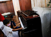 <p>También hemos visto a unos niños tocando el piano del fugado presidente del país asiático. (Foto: Dinuka Liyanawatte / Reuters).</p> 