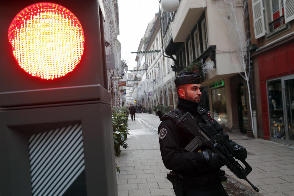 French police officer stands guards following a shooting in the city of Strasbourg, eastern France, Wednesday, Dec. 12, 2018. A man who had been flagged as a possible extremist sprayed gunfire near the city of Strasbourg's famous Christmas market Tuesday, killing three people, wounding 12 and sparking a massive manhunt. France immediately raised its terror alert level. (AP Photo/Christophe Ena)